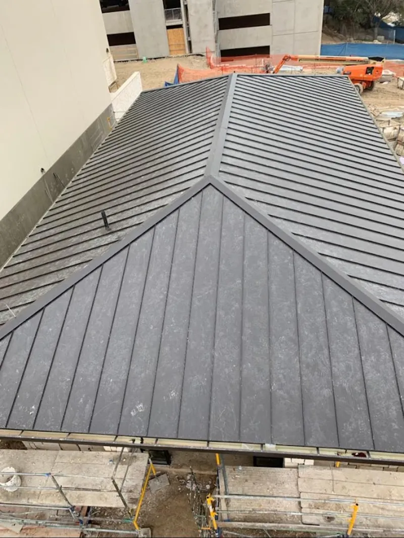 Commercial metal roof construction with crane equipment in Forest Hills