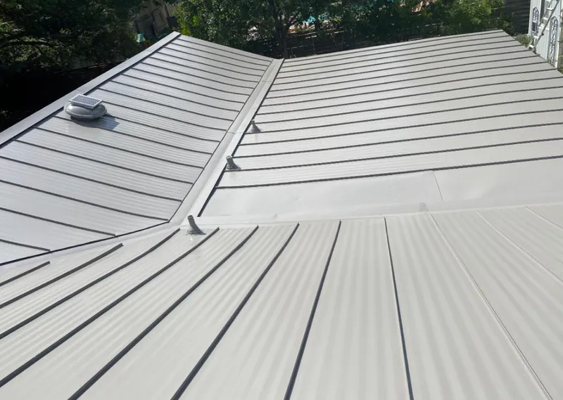Solar attic fan installed on a metal roof for Roof Ventilation in Forest Hills